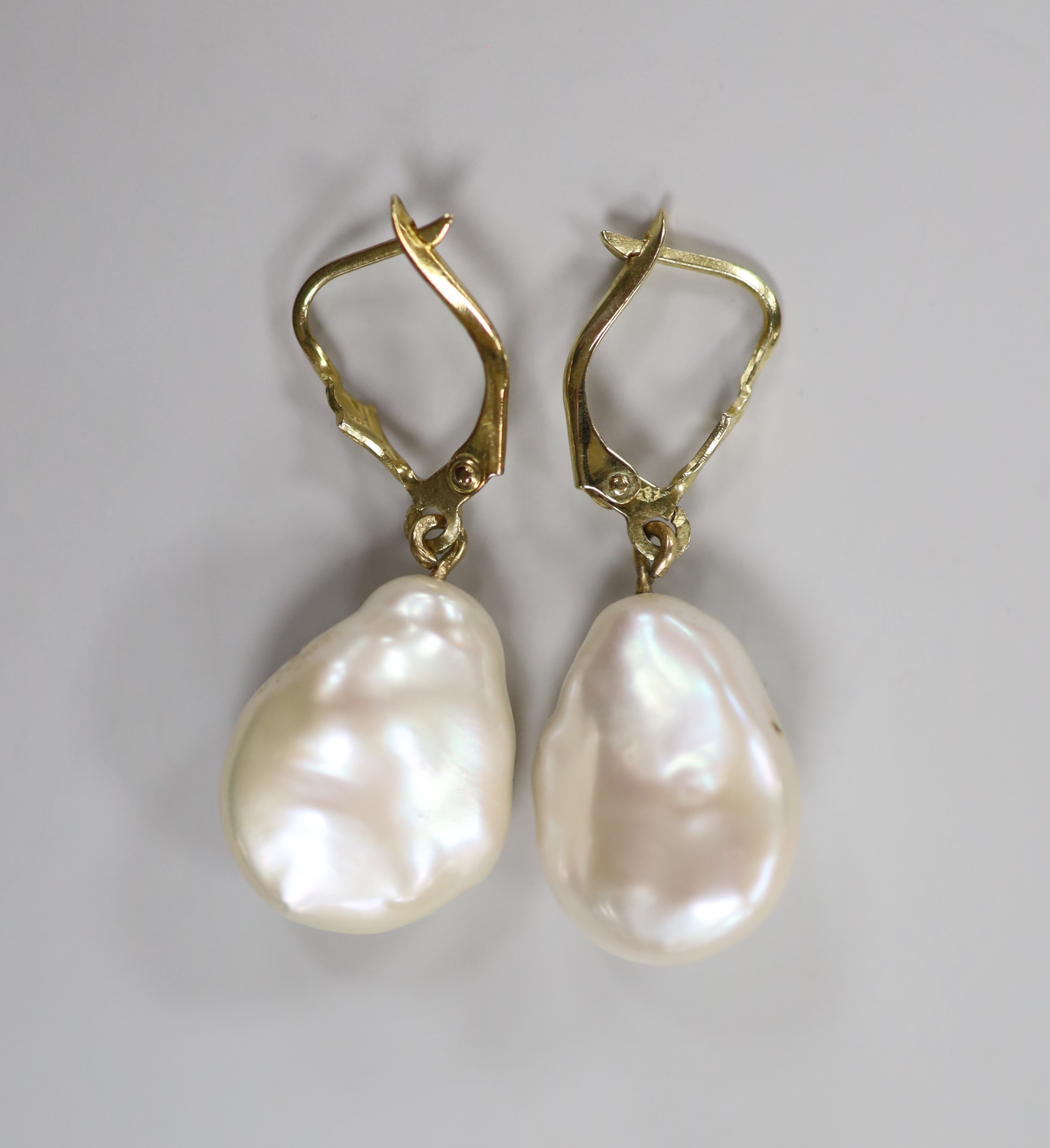 A pair of yellow metal and baroque pearl set drop earrings, each with inset rose cut diamond, pearl 17mm, gross weight 6.4 grams.